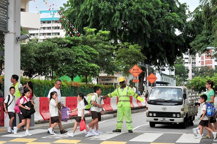 A traffic marshal guiding pupils from Hong Wen School across a zebra crossing. Sweden and the UK topped a survey of 32 countries in terms of road safety, and while Singapore was not included in the survey, data shows that it would have ranked close t