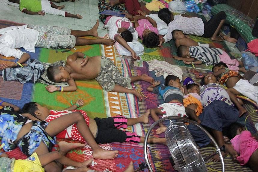 Rohingya children and women from Myanmar sleep in a confinement area in Bayeun, located in Indonesia's Aceh province after a boatload of Rohingya migrants from Myanmar and Bangladesh were rescued by Indonesian fishermen on May 20 off the Aceh coast. 