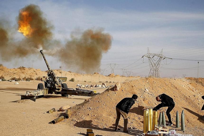 Libya Dawn fighters fire an artillery cannon at IS militants near Sirte on March 19, 2015. ISIS has seized control of the airport in the city of Sirte after forces of a Tripoli-based Libyan government withdrew, a spokesman said on Friday. -- PHOTO: R