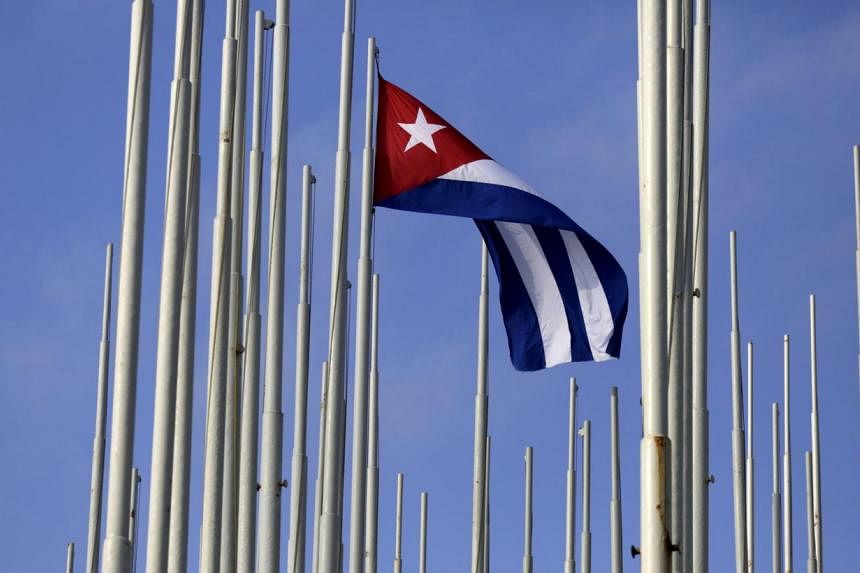 The Cuban flag flies in front of the US Interests Section (background), in Havana May 22, 2015. -- PHOTO: REUTERS&nbsp;