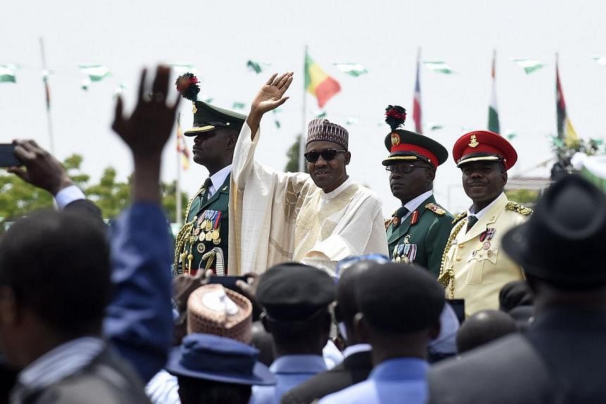 Nigerian President Muhammadu Buhari (centre) waves to the crowd during his inauguration ceremony as President of Nigeria, in Eagle Square in Abuja, Nigeria, on May 29, 2015. -- PHOTO: AFP