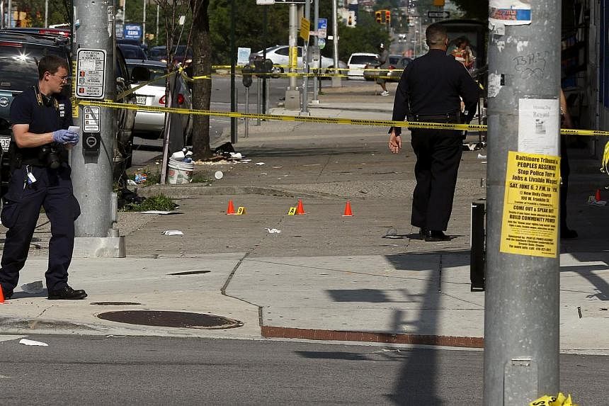 Police place evidence markers at spots where shell casings have been found at the scene of a shooting at the intersection of West North Avenue and Druid Hill Avenue in West Baltimore, Maryland on May 30, 2015. -- PHOTO: REUTERS
