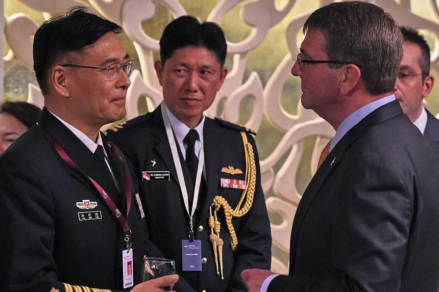 Sun Jianguo (left) from the Chinese People's Liberation Army Navy, chats with US Secretary of Defense Ashton Carter (right) during the ministerial luncheon at the 14th Asia Security Summit, the International Institute for Strategic Studies (IISS) Sha