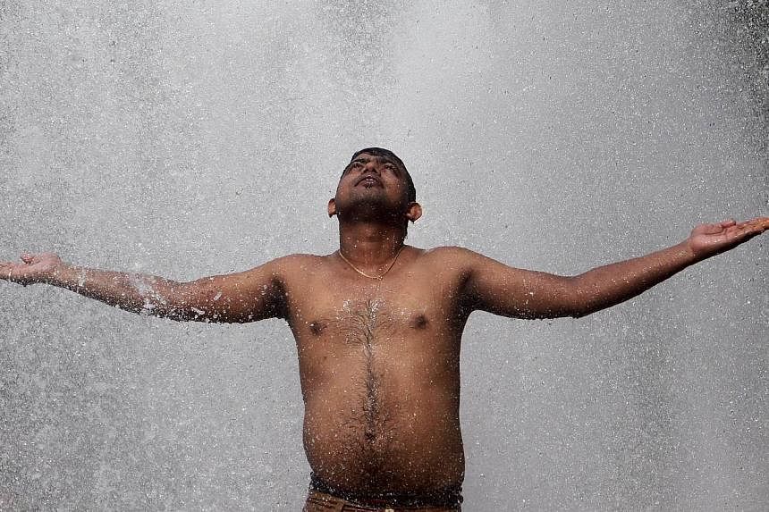 A man cools himself off at a municipal corporation water treatment plant on a hot summer day in Agartala, India, on May 31, 2015.&nbsp;Scattered rain on Sunday brought much-needed but only temporary relief to parts of India hit by a long heatwave as 
