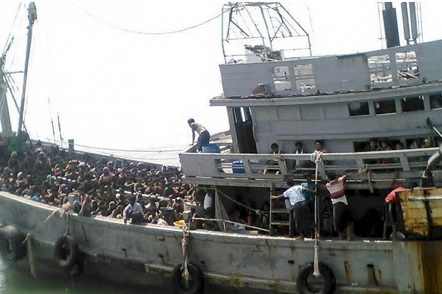 A handout picture released by the Myanmar Ministry of Information on May 30, 2015 shows migrants who were seized by the Myanmar navy in a boat near the Irrawaddy delta in Myanmar, on May 29, 2015.&nbsp;Myanmar's navy briefly detained and turned back 