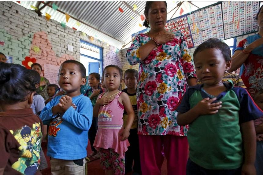 Children sing the national anthem as they start their class, a month after the April 25 earthquake, in Bhaktapur, Nepal on May 31, 2015.&nbsp;Thousands of children, many still traumatised from losing homes and loved ones, returned to class on Sunday 