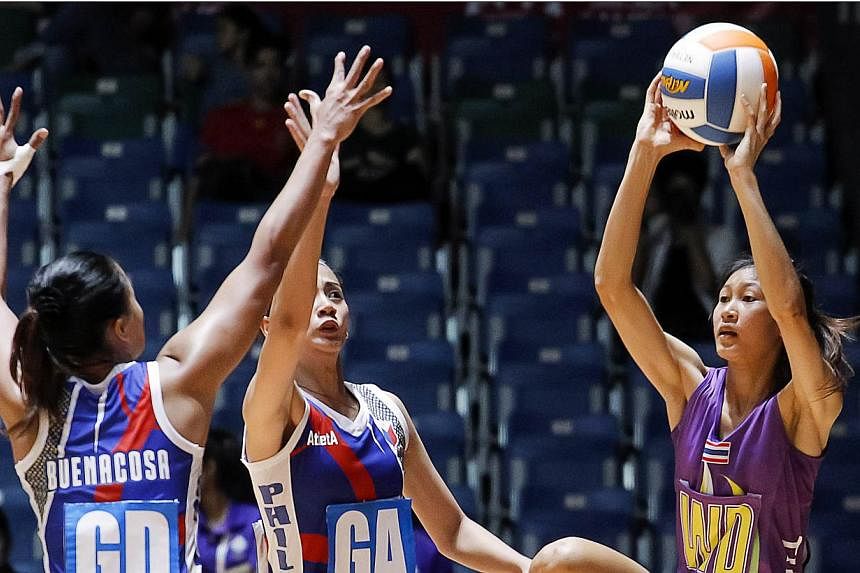 Remia Benacosa (left) and Ana Cenarosa (centre) of the Philippines defending against Thailand's Paweena Khamwan during their SEA Games netball match on Sunday, May 31, 2015. -- PHOTO: REUTERS&nbsp;