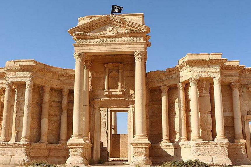 An image made available by Jihadist media outlet Welayat Homs on May 28, 2015 allegedly shows a flag of the Islamic State in Iraq and Syria (ISIS) on the circular wall bounding the Roman theatre of the ancient city of Palmyra.&nbsp;The anti-ISIS coal