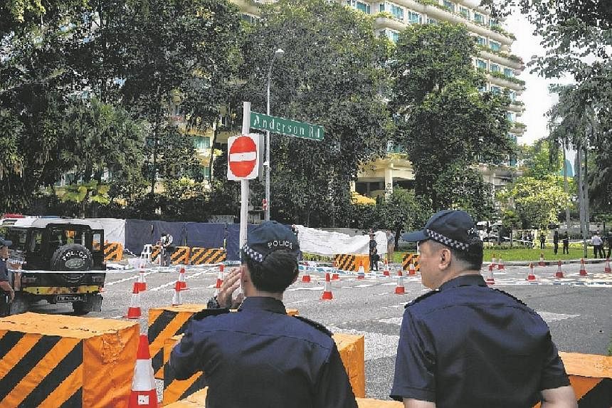 Members of the Singapore Police Force stand around a cordoned area at the junction of Orange Grove Road and Anderson Road where an early morning shooting incident occurred on May 31, 2015. A man identified as Mohamad Taufik Zahar was shot dead and tw