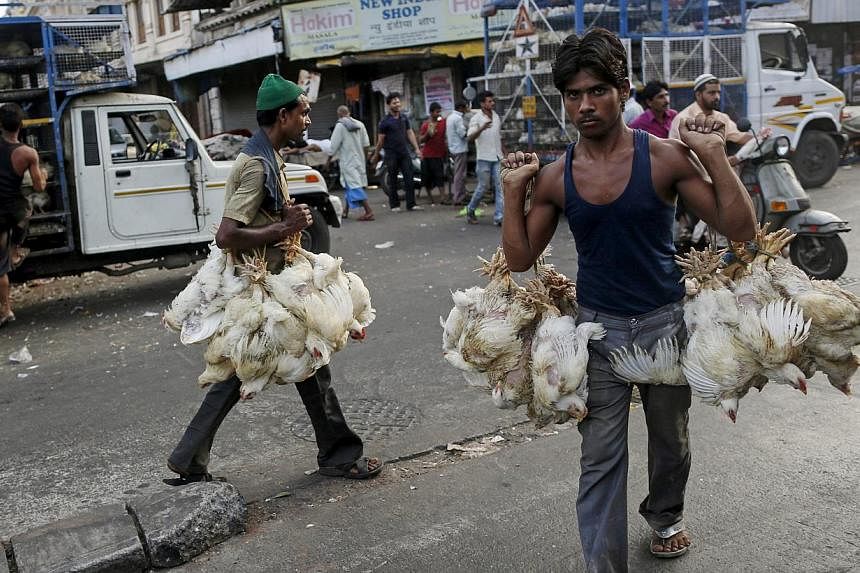 Workers carry chickens from trucks at a poultry market in Mumbai, India on June 1, 2015. Chicken prices in India soared to a record high after a heat wave killed more than 17 million birds in May, as temperatures regularly above 40 degrees Celsius le