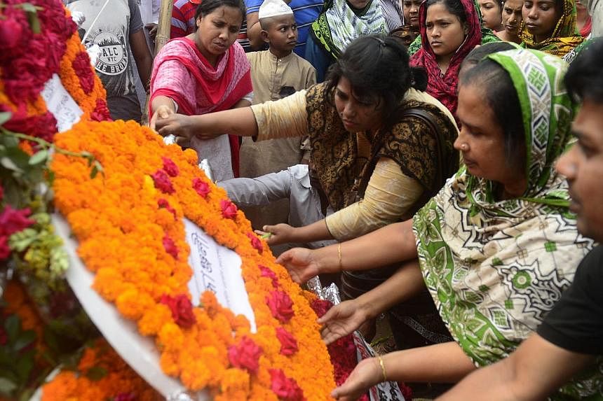 Bangladeshi people lay floral wreaths in memory of the victims of the Rana Plaza building collapse as they mark the second anniversary of the disaster in Savar, on the outskirts of Dhaka on April 24, 2015. Bangladeshi police on Monday, June 1, charge