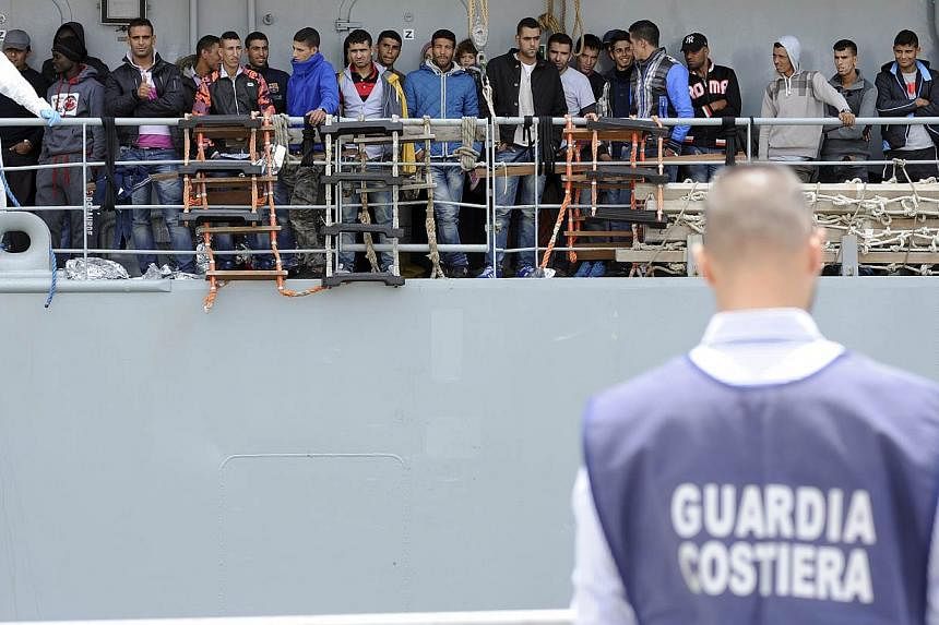 Migrants wait to disembark from the Irish navy ship LE Eithne as they arrives in the Sicilian harbour of Palermo, Italy, on May 30, 2015.&nbsp;European powerhouses France and Germany on Monday, June 1, called on the EU to revise its plan to admit asy
