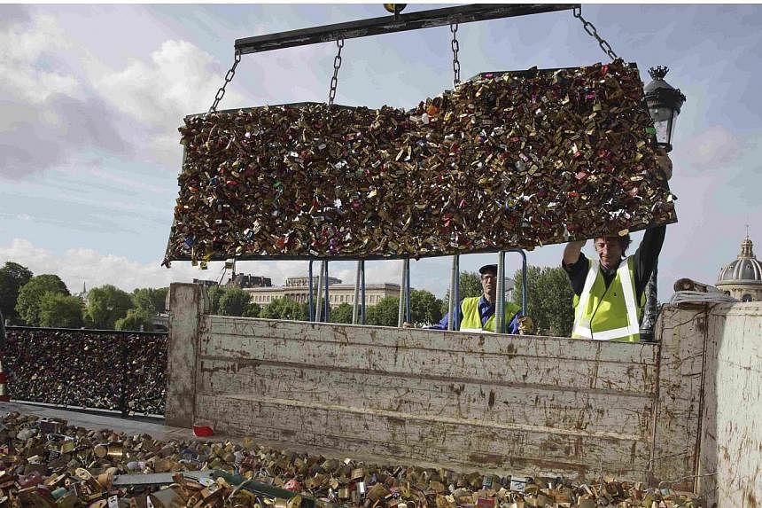 City municipal employees lower iron grills covered with "love locks" into a truck after they were removed from the Pont des Arts in Paris, France, on June 1, 2015. Parisian authorities on Monday removed tens of thousands of "love locks", padlocks cha