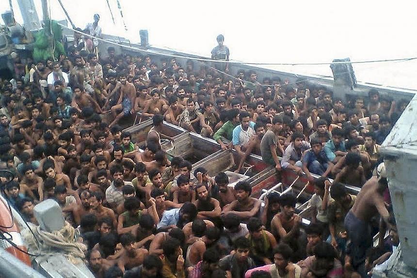 A handout picture released by the Myanmar Ministry of Information on May 30, 2015 shows migrants who were seized by the Myanmar navy in a boat near the Irrawaddy delta on May 29, 2015.&nbsp;The migrants were still being held offshore by Myanmar's nav
