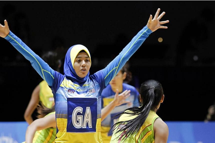 Malaysia's netballer Izyan Syazana Mohd Wazir (left) in action at the SEA Games 2015. Defending SEA Games netball champion Malaysia sent out a statement of intent to the other teams with a ruthless 112-11 thrashing of the Philippines on June 1, 2015 
