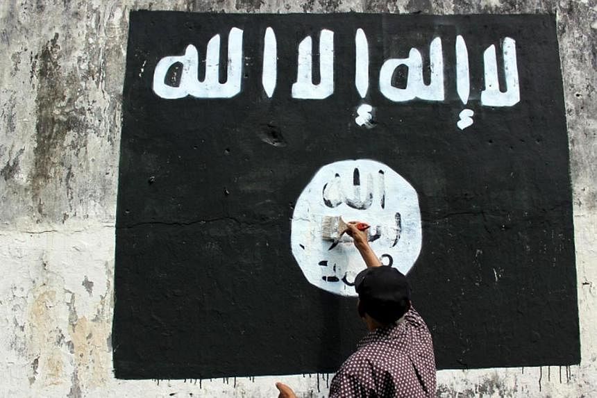 A resident painting over an ISIS flag in Solo, Central Java. The Islamic State in Iraq and Syria (ISIS) has ramped up its activities in South-east Asia so effectively that there is now an entire military unit of terrorists recruited from Indonesia, M