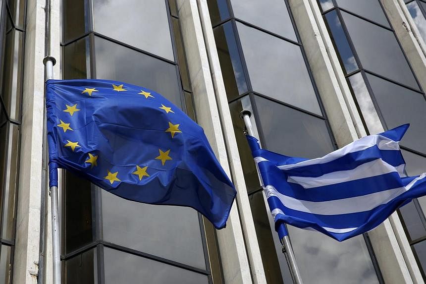 A Greek and an EU flag flutter outside the Foreign Ministry in Athens on March 12, 2015. -- PHOTO: REUTERS