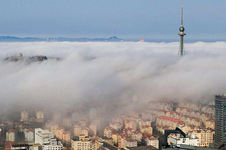 Residential buildings are seen among fog in Qingdao, Shandong province. China's housing sales in major cities, measured by floor space, jumped 37.4 per cent in May from a year earlier, a private survey showed on Tuesday, helped by government's stimul