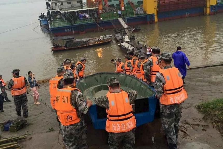 Rescue workers carrying a boat to conduct a search after a ship sank at the Jianli section of Yangtze River, Hubei province, on June 2, 2015. -- PHOTO: REUTERS