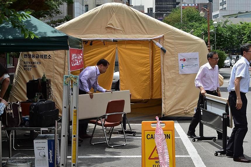 South Korean hospital workers settting up a separate emergency centre for Mers cases at the National Medical Center in Seoul on June 1, 2015. The country's health ministry confirmed on Tuesday that two people had died from the virus. -- PHOTO: AFP&nb
