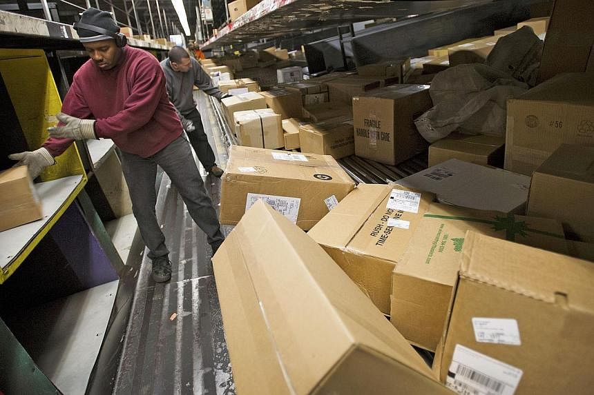 Employees sorting through packages at a United Parcel Service sorting facility in San Francisco, California, in 2012. Yet another app is launching in Singapore to match parcel senders with the nearest couriers. -- PHOTO: BLOOMBERG