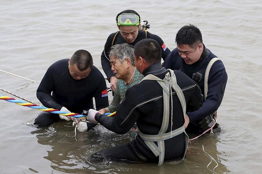 A woman is helped after being pulled out by divers from a capsized ship in Jianli, Hubei province, China on June 2, 2015. Rescuers are working to save five more passengers trapped inside the hull of the ship that capsized in China's Yangtze River&nbs