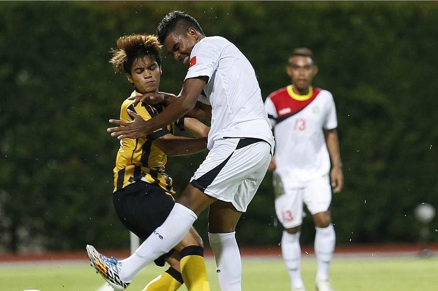 Malaysia's Muhammad Nazmi Faiz Mansor (left) collides with Timor Leste's Filipe Oliveira during one of their few notable altercations in the 28th SEA Games men's football first round group B match at the Bishan Stadium on May 30, 2015.&nbsp;Nazmi has