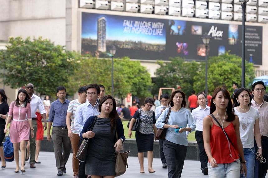 Office workers at Raffles Place on Feb 18, 2015. Employees in Singapore could see their salaries grow by 4.4 per cent this year, on the back of low inflation, according to a survey released on Tuesday. -- ST PHOTO: DANIEL NEO