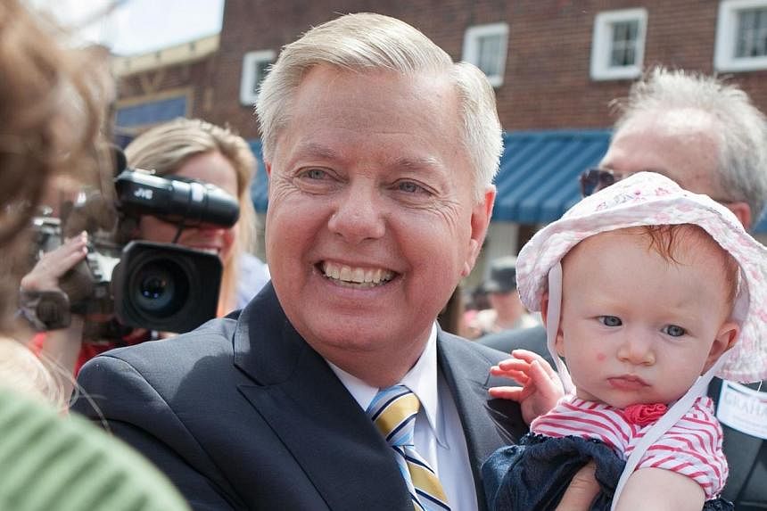 US Senator Lindsey Graham. a Republican representing South Carolina, holds a supporter's baby after announcing his candidacy for United States President during an outdoor event on June 1 in his home state. -- PHOTO: AFP