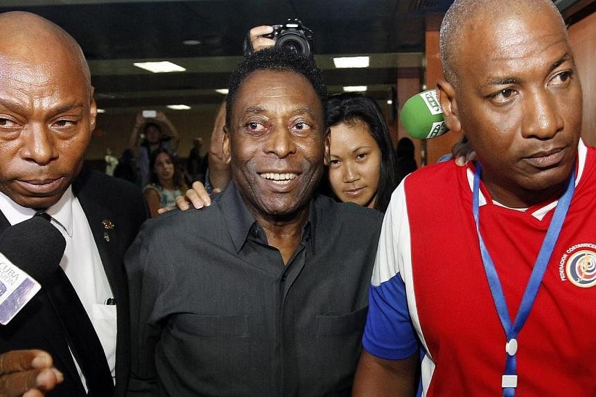 Former football superstar Edson Arantes do Nascimiento Pele (centre) arrives in Havana, Cuba on Sunday (May 31) where he told journalists that he supports the re-election of Joseph Blatter as president of FIFA. -- PHOTO: EPA