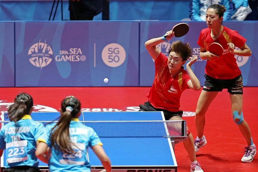 Singapore paddlers Yu Mengyu (far right) and Feng Tianwei in action against Thailand in the SEA Games women's doubles quarter-finals at the Singapore Indoor Stadium on June 1, 2015. -- ST PHOTO: SEAH KWANG PENG