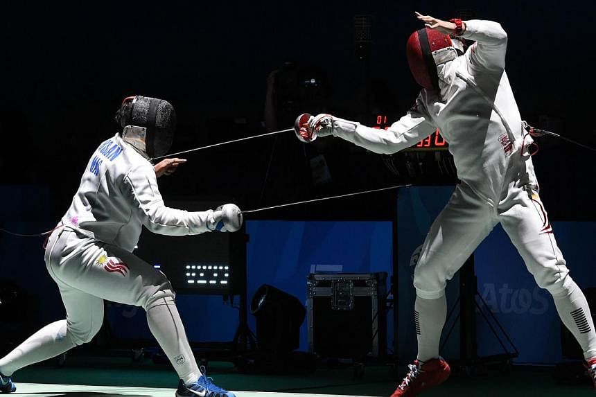 Malaysia's Mohamad Roslan Mohamed (left) competes with Singapore's Lim Wei Wen (right) in their men's individual epee round of 16 fencing match during the 28th Southeast Asian Games (SEA Games) in Singapore on June 3, 2015. -- PHOTO: AFP