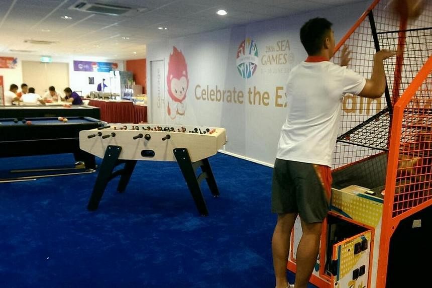 Singapore rugby player Samuel Teo trying out the basketball machine in the Nila Suite. -- ST PHOTO: HO SI RUI&nbsp;