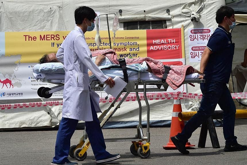 South Korean hospital workers wheeling a man in front of a quarantine tent for suspected Mers cases at the Seoul National University Hospital in Seoul on June 2, 2015. -- PHOTO: AFP