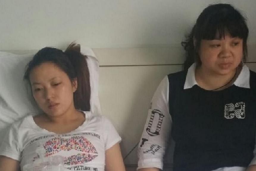 Ms Tan Mei (left) and Ms Chen Jian, wife and sister of missing crew member Chen Bo, 33, await news at a hotel in Jianli county, Hubei province. -- PHOTO: KOR KIAN BENG