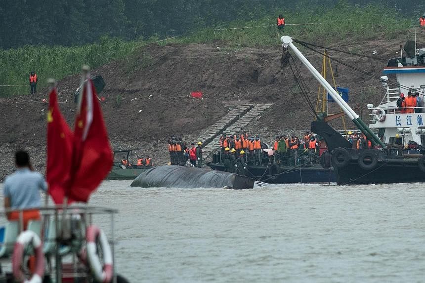 &nbsp;Rescue workers are seen on the hull of capsized passenger ship Dongfangzhixing or "Eastern Star" in the Yangtze river at Jianli in China's Hubei province on June 3, 2015. -- PHOTO: AFP
