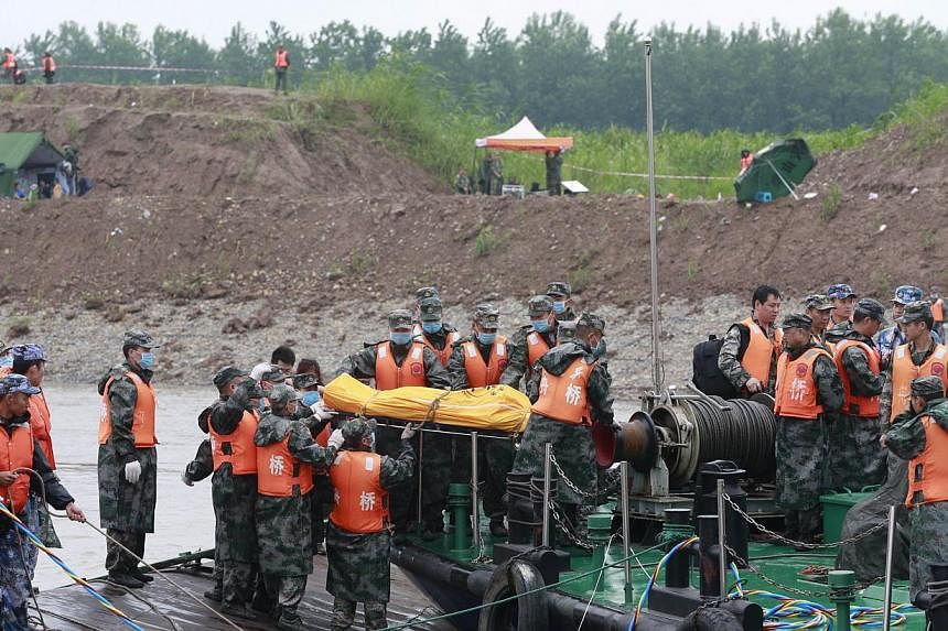 Rescue personnel move the remains of victims who were travelling on the capsized passenger ship Dongfangzhixing or "Eastern Star" onto a boat in the Yangtze river at Jianli in China's Hubei province on June 3, 2015. &nbsp;-- PHOTO: AFP