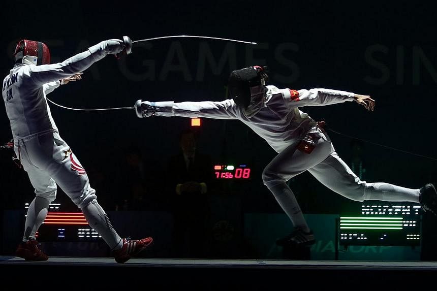 Vietnam's Nguyen Tien Nhat (right) beats Singapore's Lim Wei Wen (left) 15-8 during the finals of the Men's individual épée match held at the OCBC Arena Hall 2 on June 3, 2015. -- ST PHOTO: NEO XIAOBIN&nbsp;