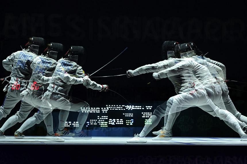 Singapore's Wang Wenying (right) beats Philippines's Justine Gail Tinio (left) 15-7 during the SEA Games fencing Women's individual foil finals held at the OCBC Arena Hall 2 on June 3, 2015. -- PHOTO: REUTERS