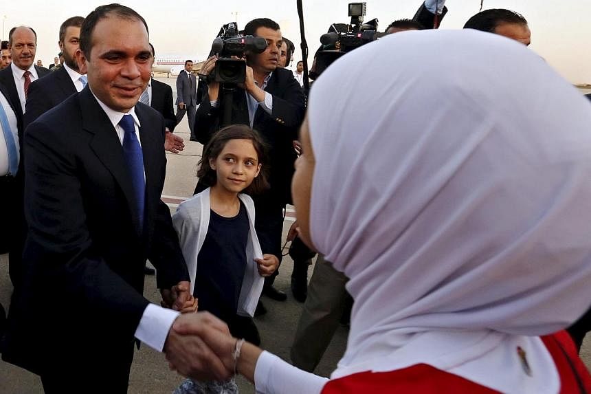 Members of the Jordanian women's national soccer team welcome Jordan's Prince Ali bin Al Hussein (left), upon his arrival at Queen Alia International Airport in Amman, after his return from participating in the International Federation of Association
