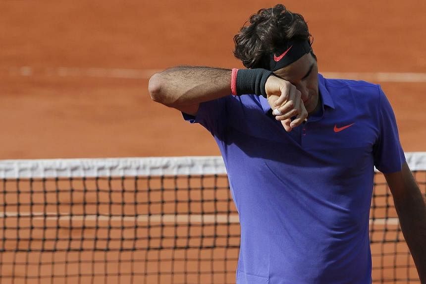 Roger Federer of Switzerland wipes his face during his men's quarter-final match against his compatriot Stan Wawrinka during the French Open tennis tournament at the Roland Garros stadium in Paris on Tuesday (June 2). -- PHOTO: REUTERS