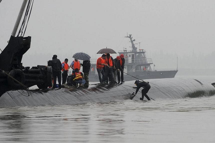 A diver (right) preparing to dive in the river to search for survivors after a ship sank at the Jianli section of the Yangtze River, Hubei province, China, on June 2, 2015. -- PHOTO: REUTERS