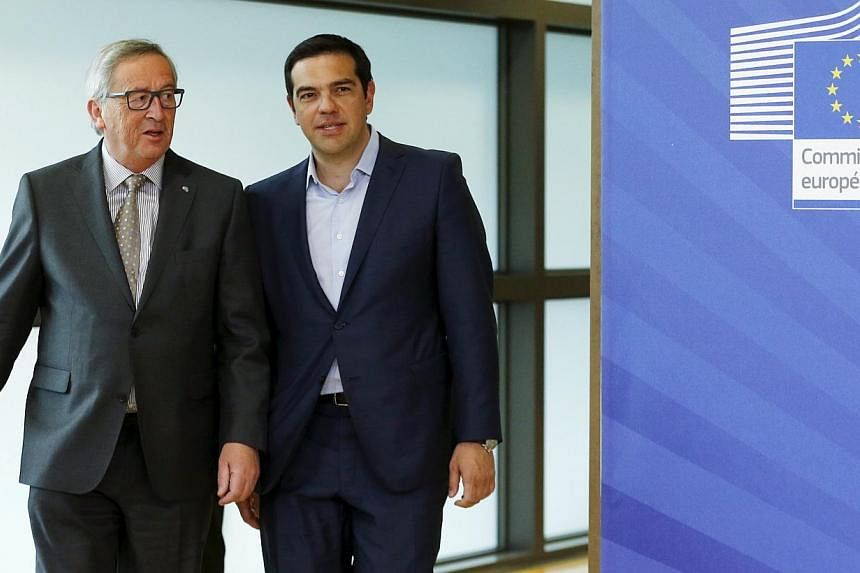 Greek Prime Minister Alexis Tsipras walks with European Commission President Jean-Claude Juncker (left) ahead of a meeting at the EU Commission headquarters in Brussels, Belgium, on June 3, 2015. -- PHOTO: REUTERS