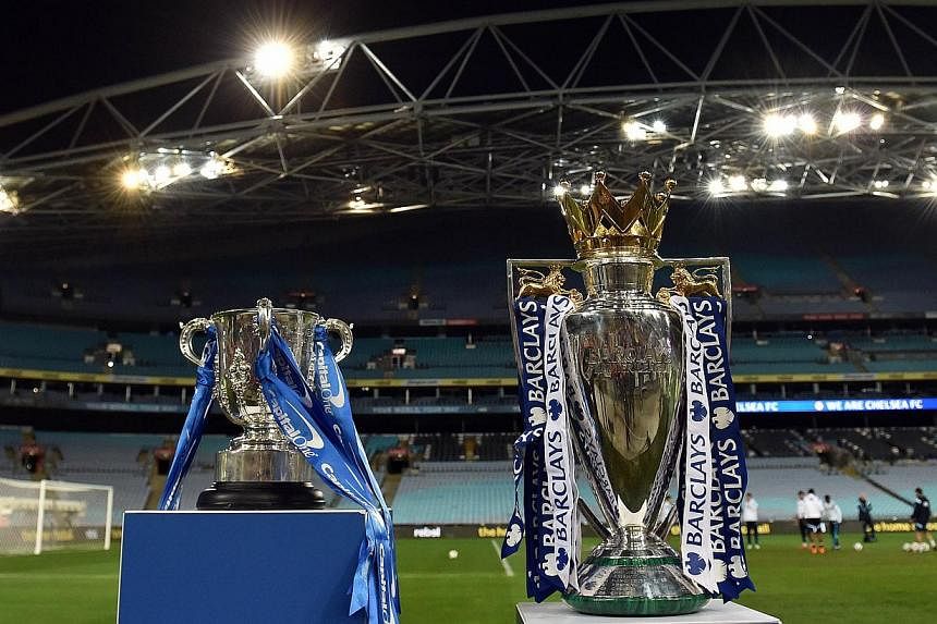 The Capital One cup (left) and English Premier League trophy are displayed as players from Chelsea take part in a football training session in Sydney on June 1, 2015. English Premier League clubs generated record combined revenues of £3.26 billion (