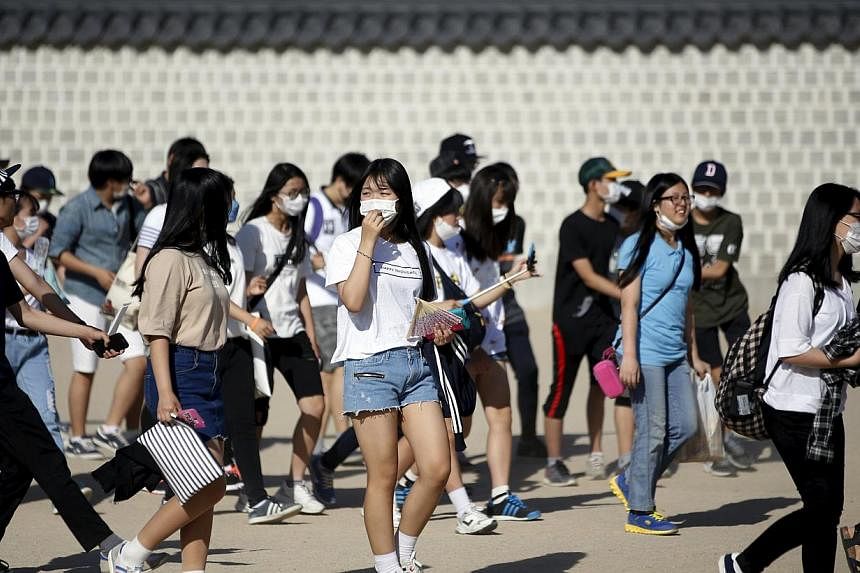 South Korean students wearing masks to prevent contracting Middle East Respiratory Syndrome (MERS) walk at the Gyeongbok Palace in central Seoul, South Korea, on June 3, 2015. -- PHOTO: REUTERS