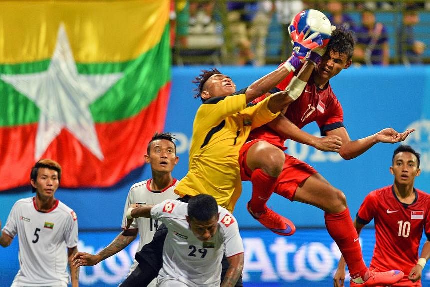 Myanmar's goalkeeper Phyo Kyaw Zin challenges Singapore's Irfan&nbsp;Fandi Ahmad (in red, no.17) for the ball in the Singapore VS Myanmar football match of the 28th SEA Games played at Jalan Besar Stadium on June 4, 2015. Myanmar won the match 2-1. -