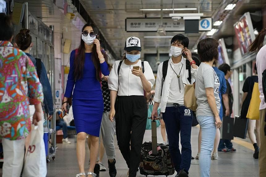 People wearing face masks walk through a subway station in the popular Myeongdong shopping area in Seoul on June 4, 2015. South Korea has reported a third fatality in a Mers virus outbreak that has fuelled growing alarm in the country. -- PHOTO: AFP