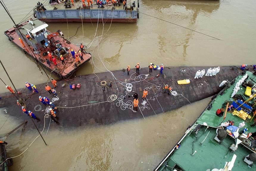 An aerial view shows rescue workers standing on the sunken cruise ship Eastern Star in Jianli, Hubei province, China on June 4, 2015. Rescue officials on Thursday began the operation to right the vessel. -- PHOTO: REUTERS