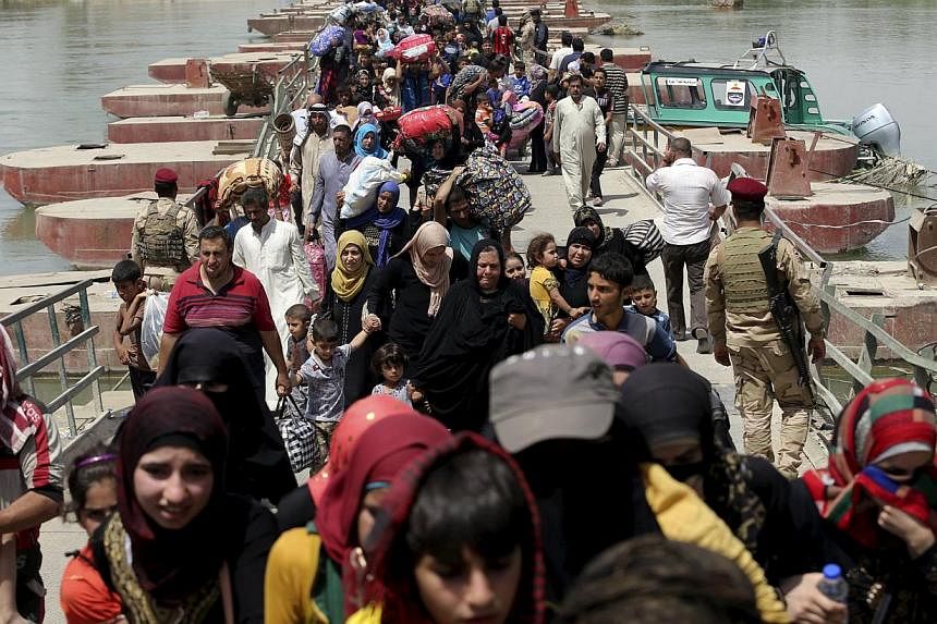 Displaced Sunni people fleeing the violence in Ramadi, cross a bridge on the outskirts of Baghdad on May 24, 2015. The United Nations is appealing for US$497 million (S$670 million) to pay for shelter, food and water over the next six months for 5.6 
