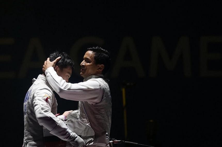 Thailand's Panchan Nontapat (right) beats Singapore's Kevin Jerrold Chan 15-6 in the SEA Games fencing men's individual foil semifinals held at the OCBC Arena Hall 2 on June 4, 2015.&nbsp;-- ST PHOTO: NEO XIAOBIN